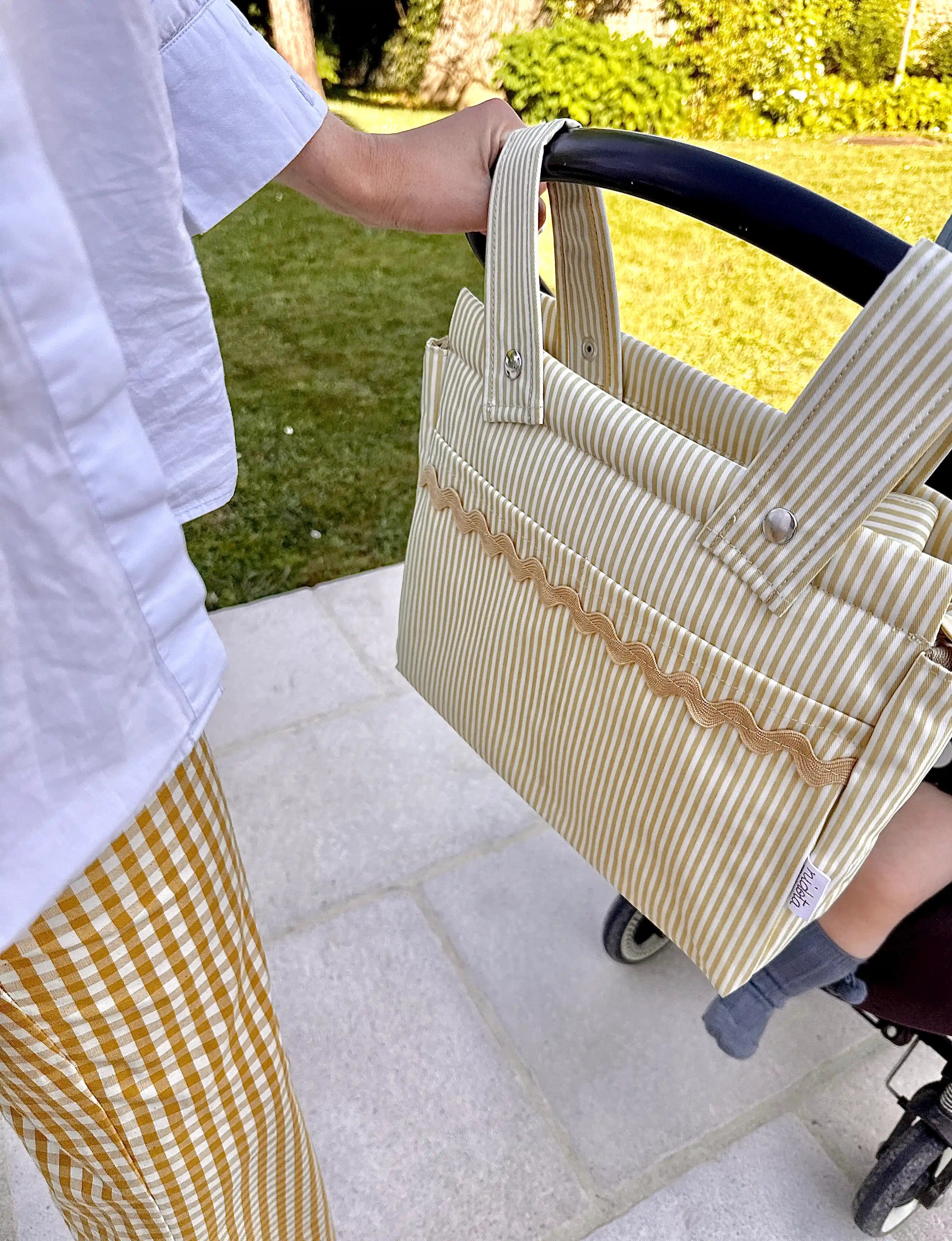 baby stroller striped beige bag attached to a stroller