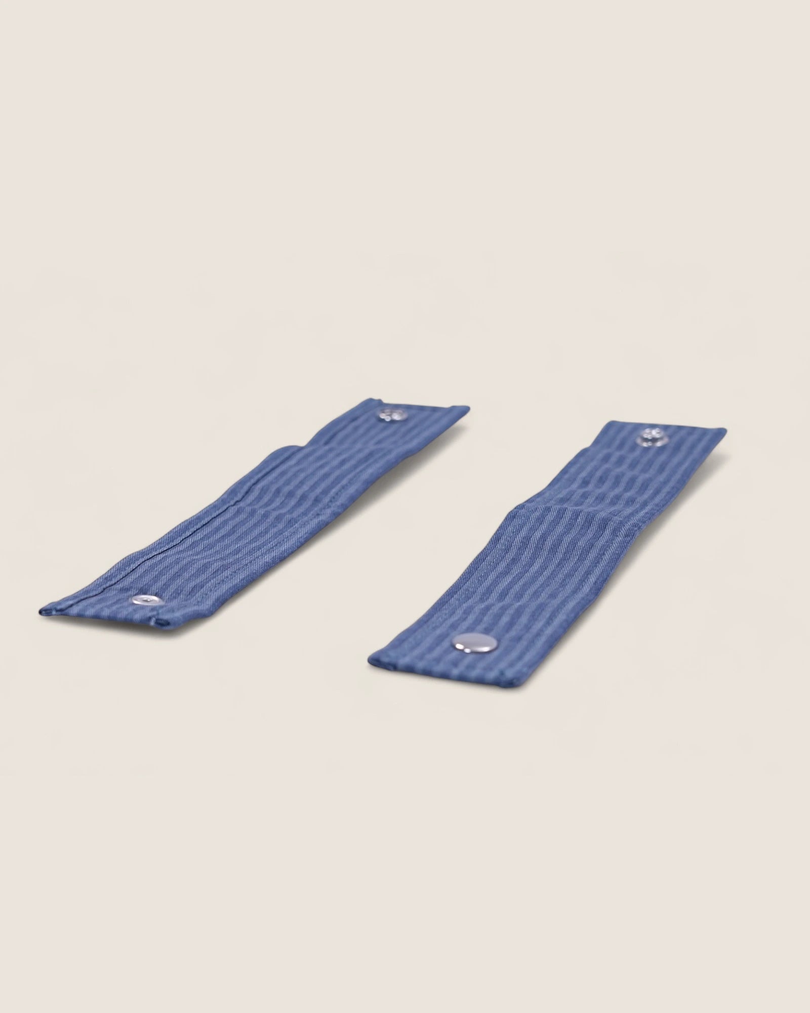 Two blue wristbands for baby stroller bag on a beige background