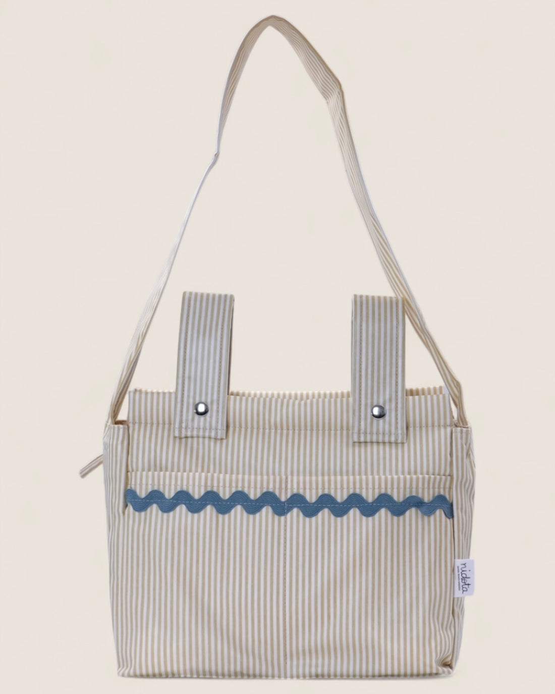 Striped baby stroller bag with blue decorative trim on a beige background