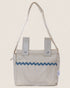 Striped baby stroller bag with blue decorative trim on a beige background