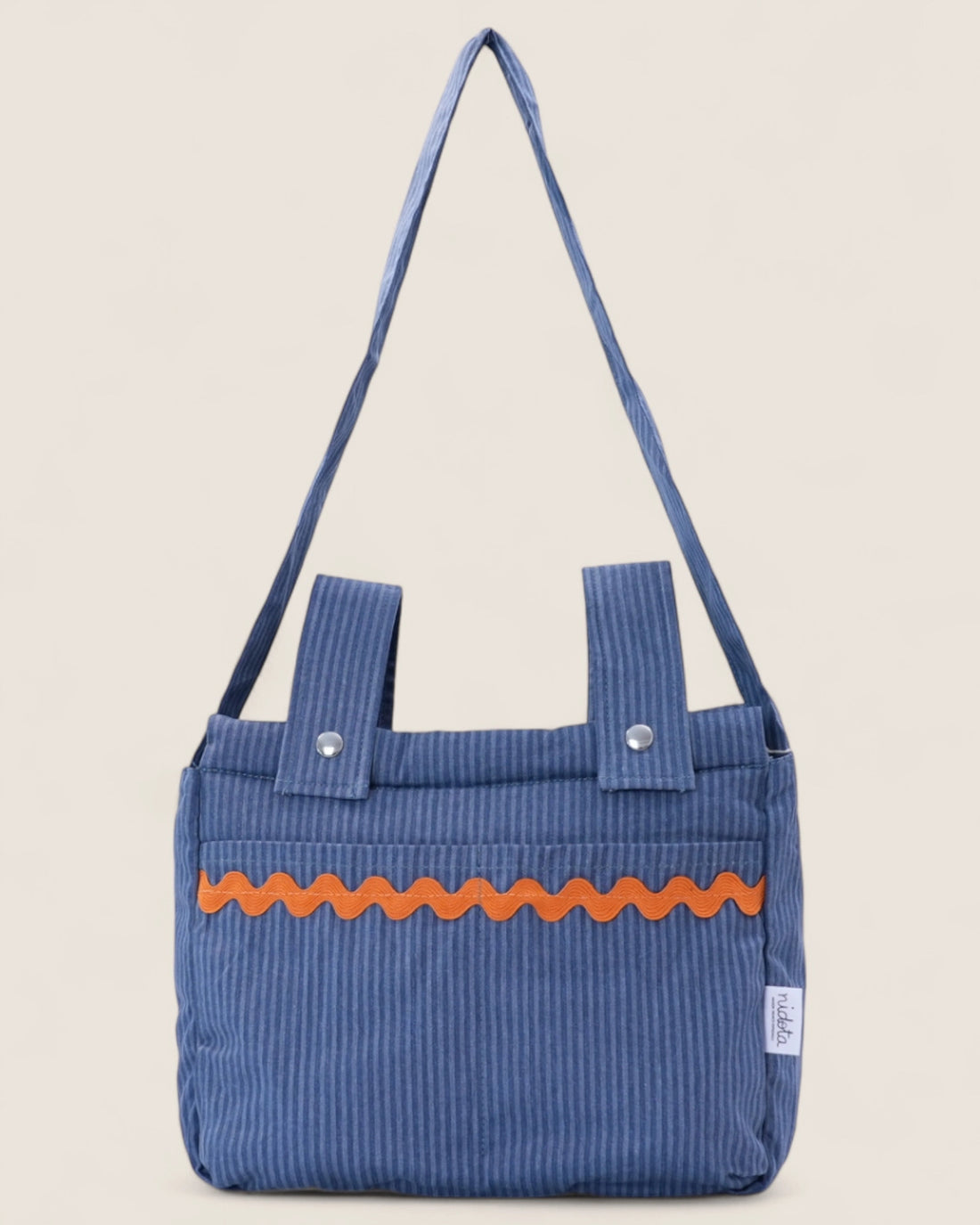 striped blue baby stroller bag with orange accents on a beige background
