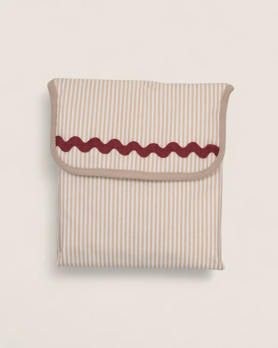 folded baby changing mat, beige striped with red waved detail