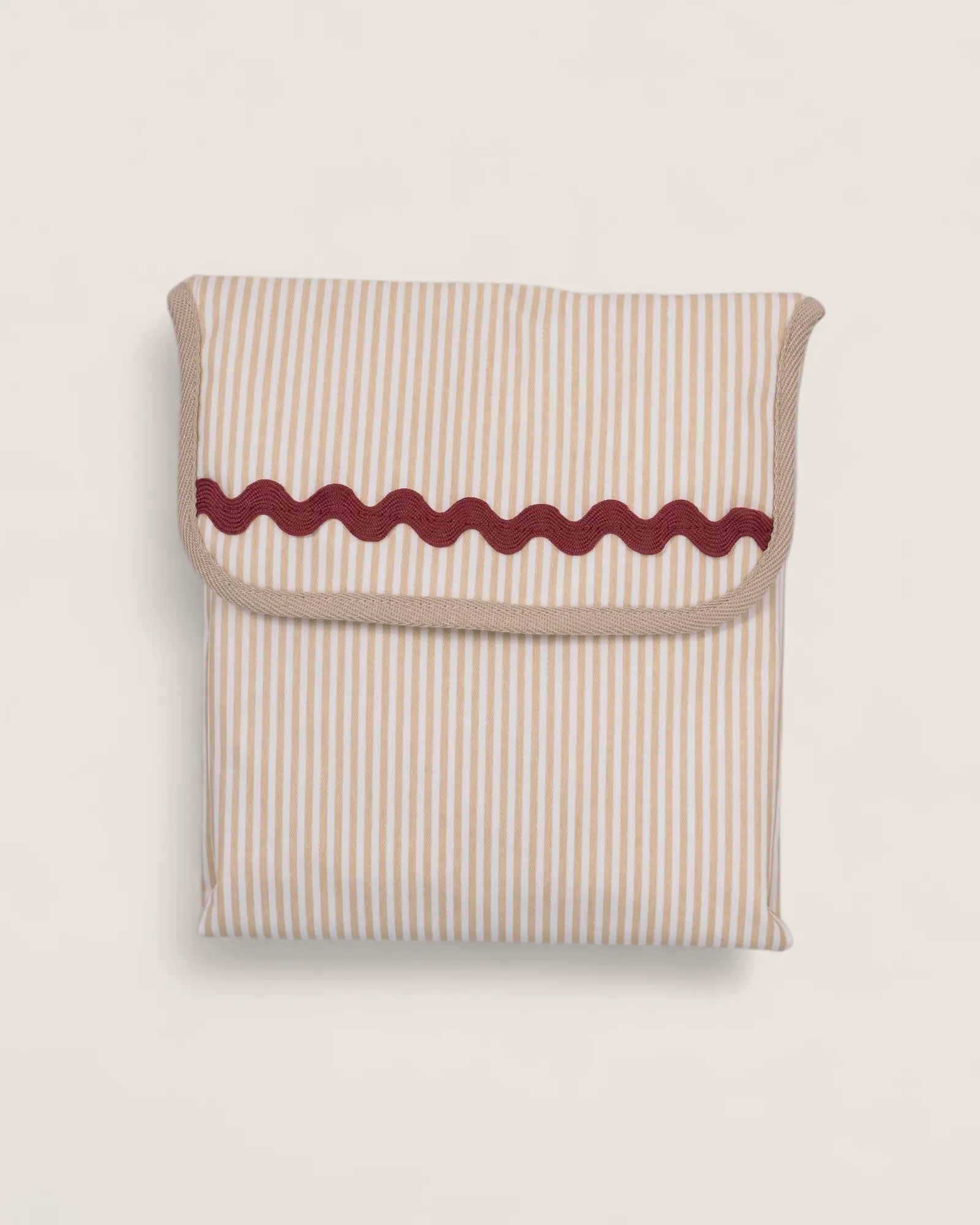 folded baby changing mat, beige striped with red waved detail