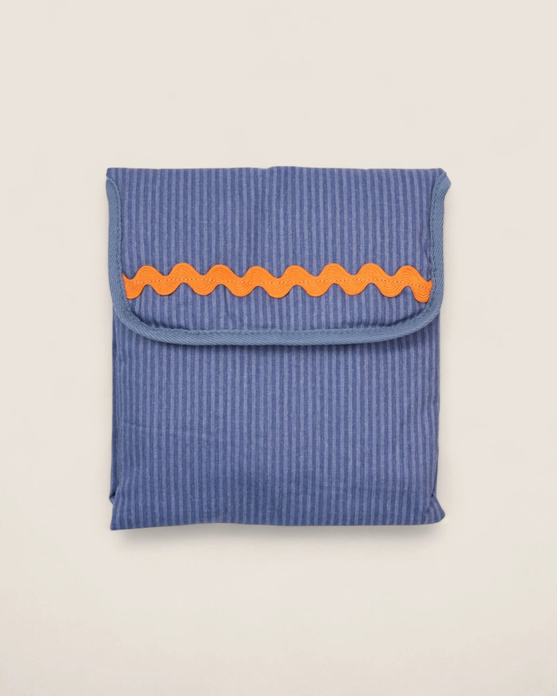 striped blue baby changing mat folded with an orange waved design