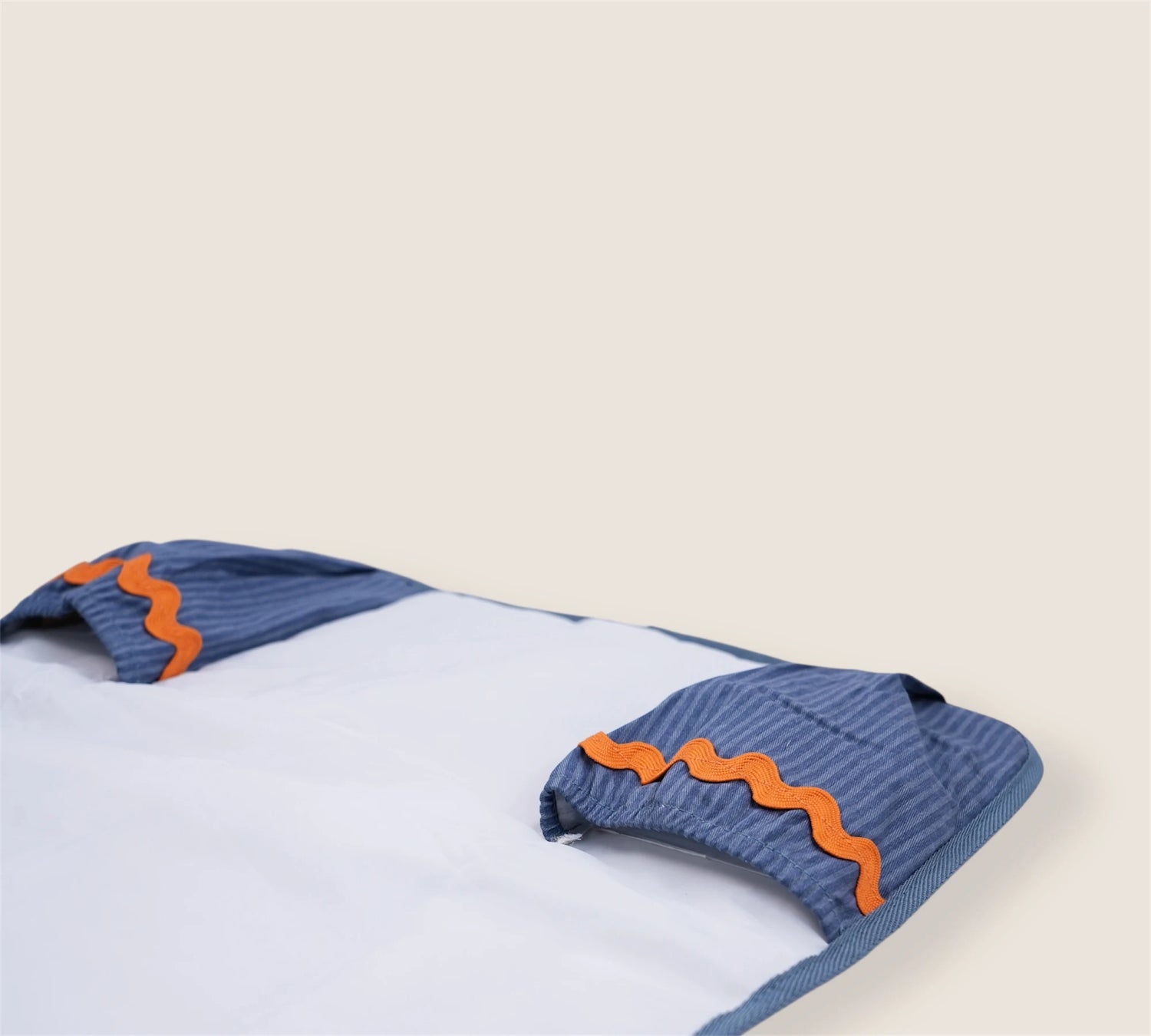baby changing mat with pockets fir diapers and wipes and a waved orange detail
