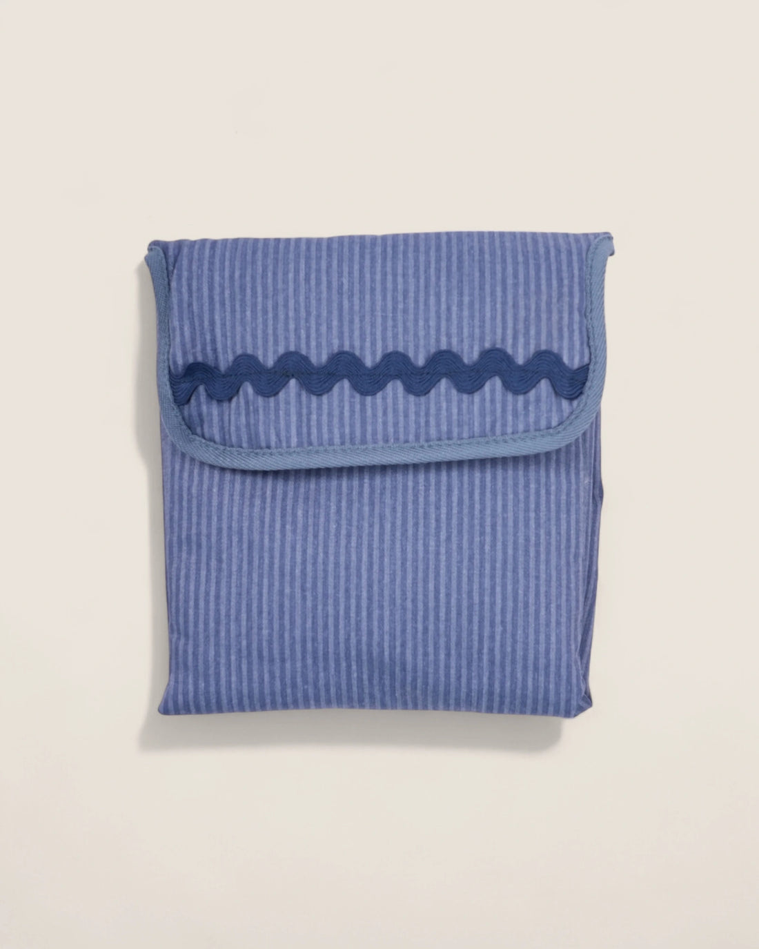 folded blue striped baby changing mat with navy waved design
