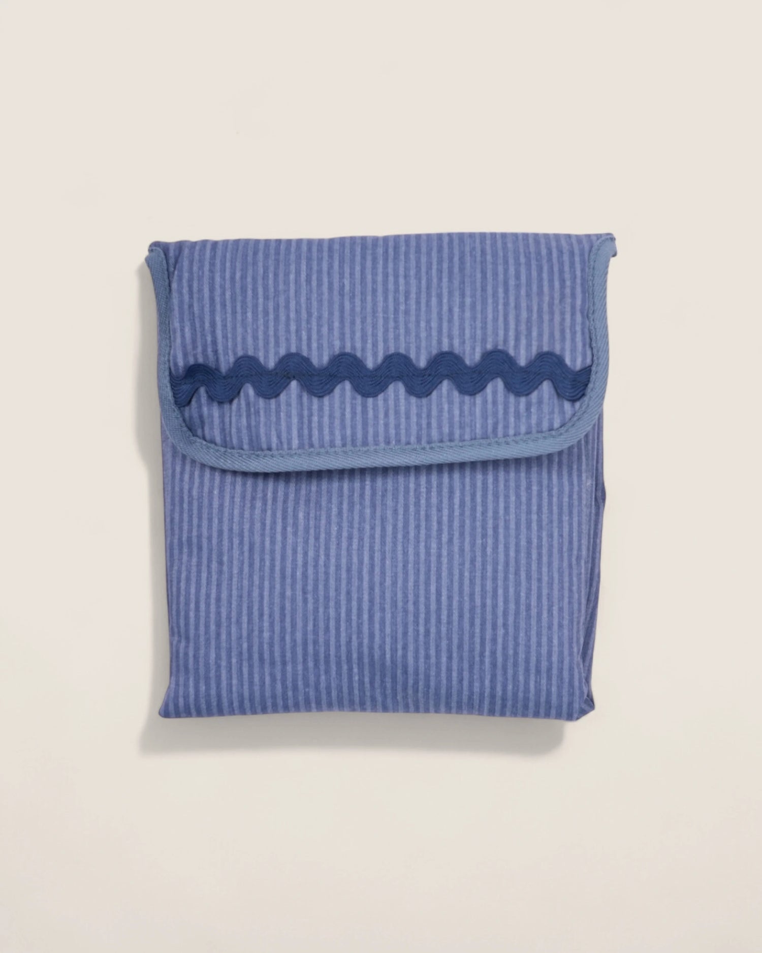 folded blue striped baby changing mat with navy waved design