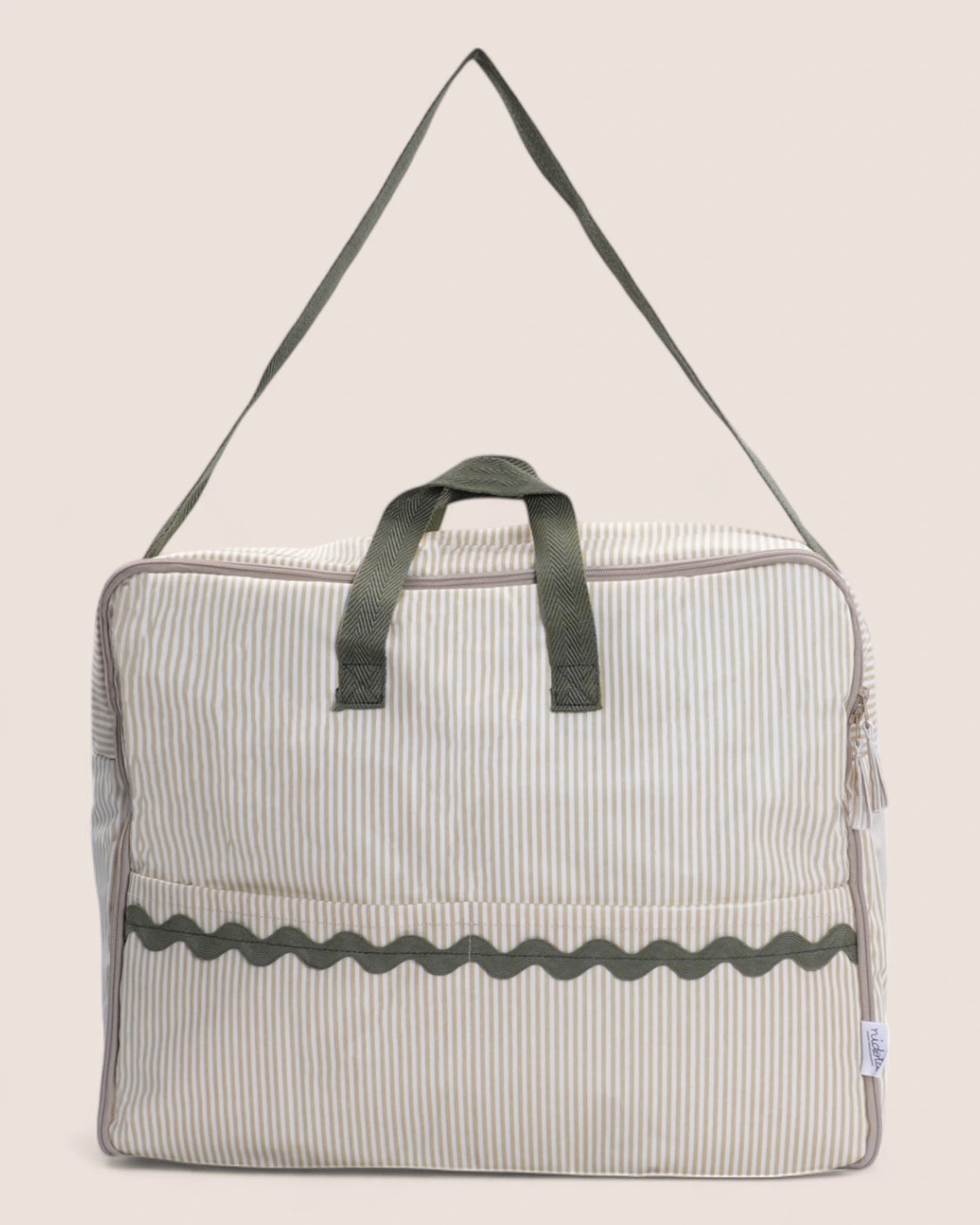Striped bag with green handle on a beige background