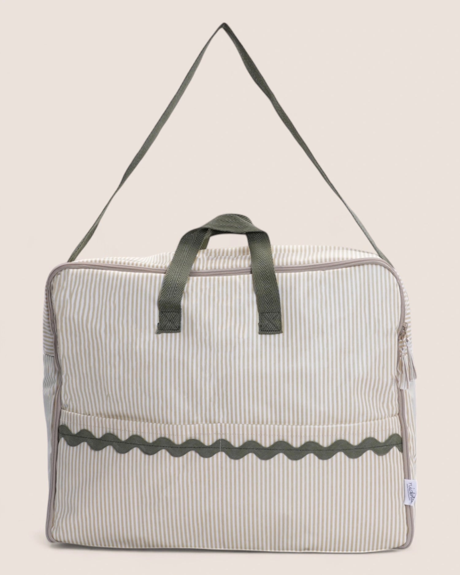 Striped bag with green handle on a beige background