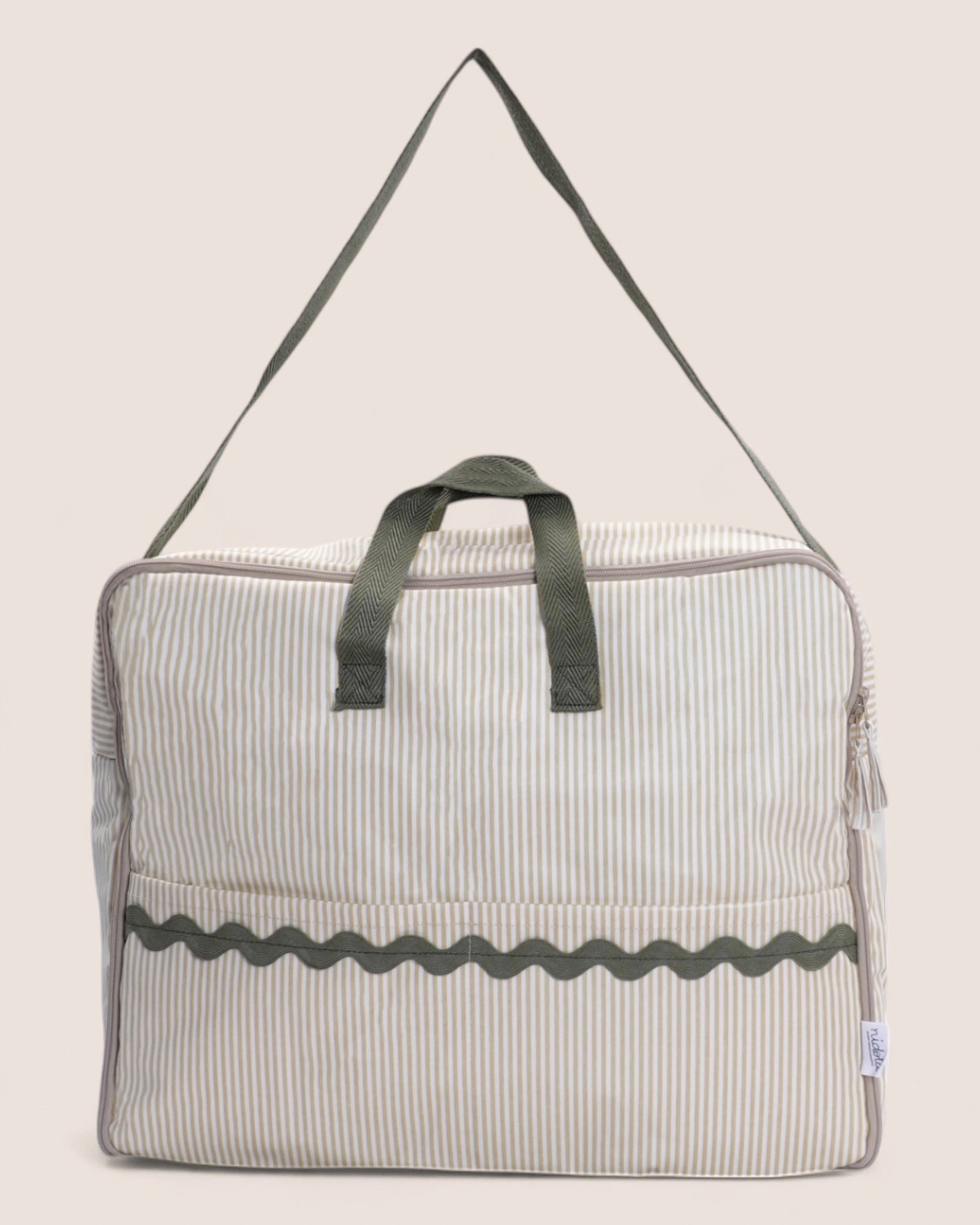 Striped bag with green handle on a beige background