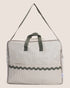 Striped bag with green handle on a beige background