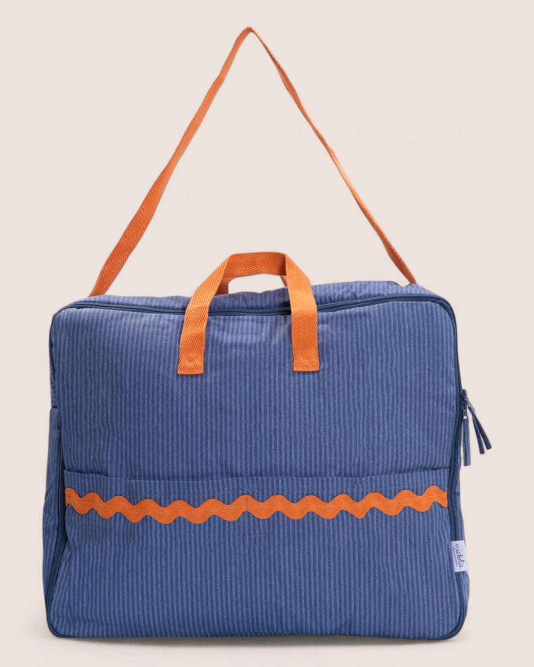 Blue striped maternity suitcase bag with orange waved detail and handles on a beige background
