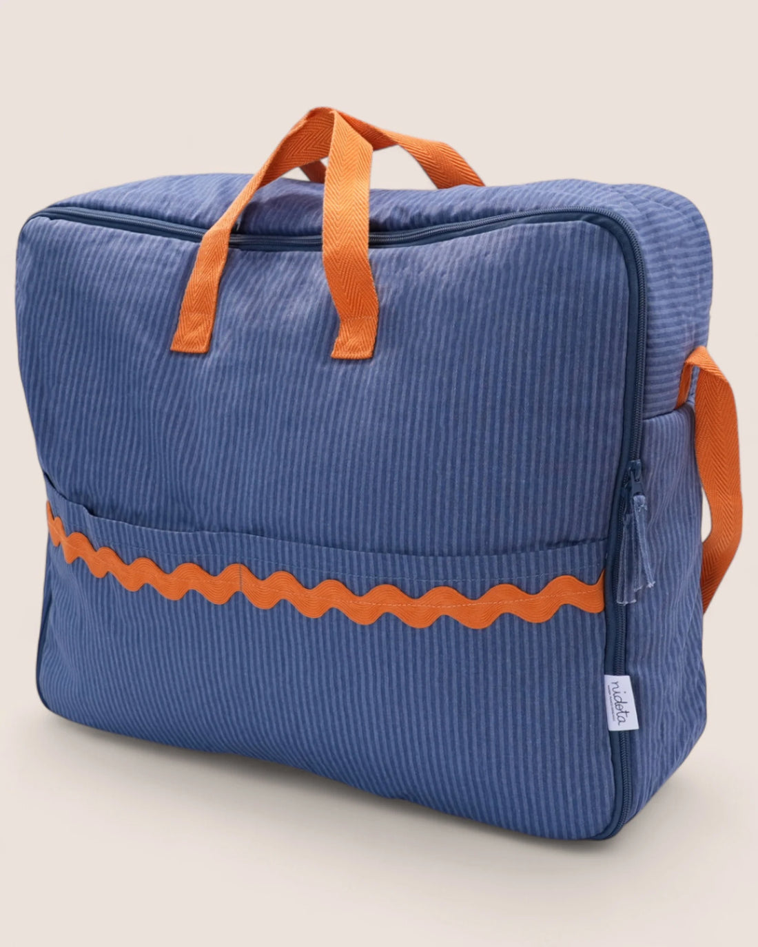 Blue striped maternity suitcase bag with orange waved detail and handles on a beige background