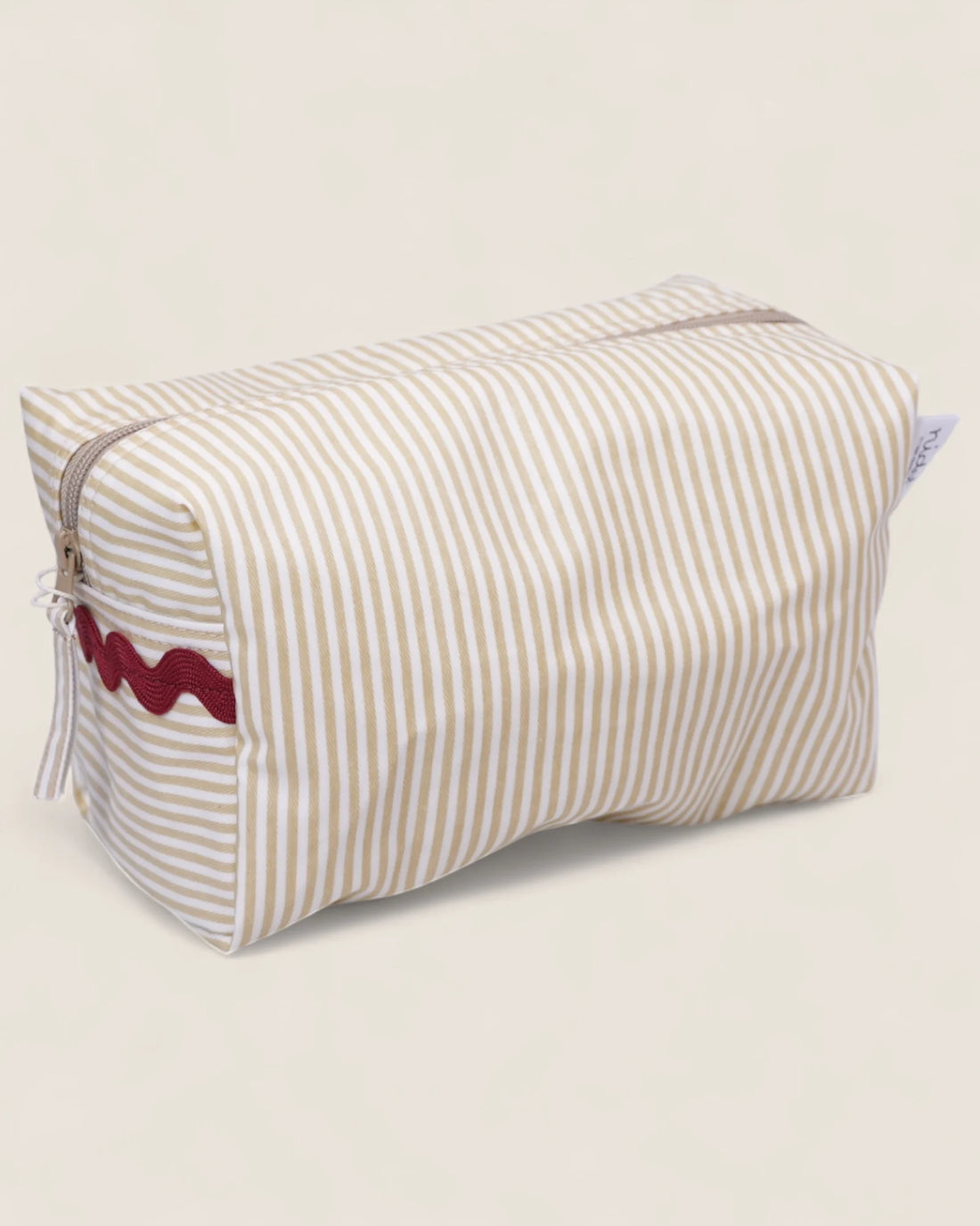 Striped beige toiletry bag with red details