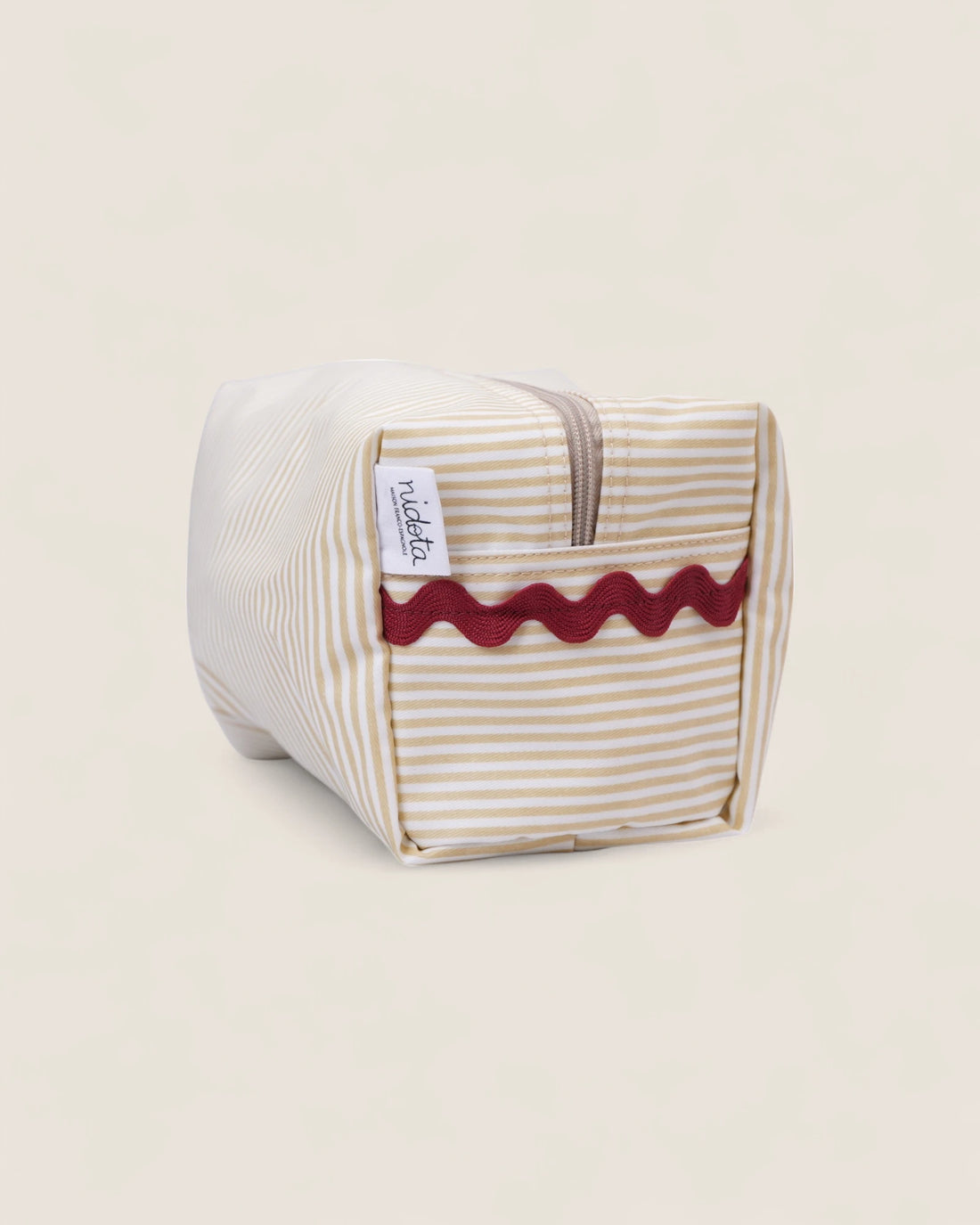 Striped beige toiletry bag with a red wavy design 