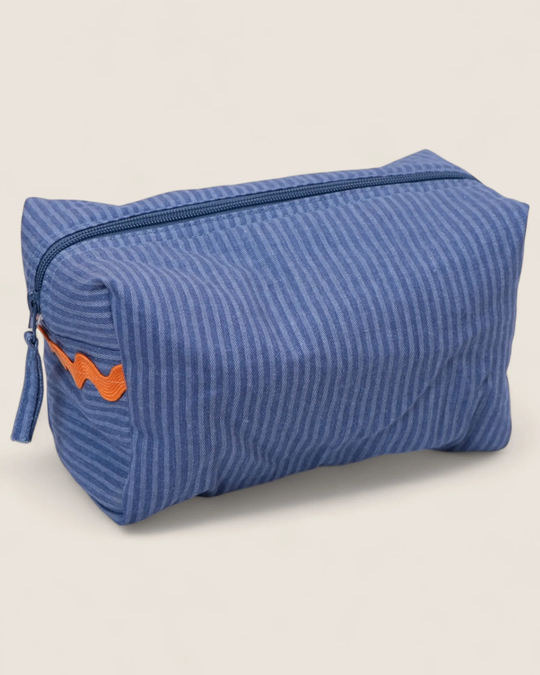 Blue striped toiletry bag with orange waved design and blue zipper