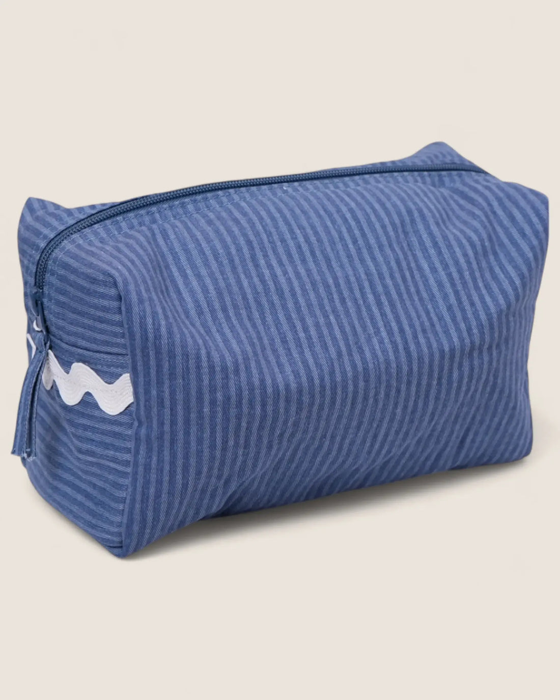 Blue striped toiletry bag with a white lwaved detail and blue zipper