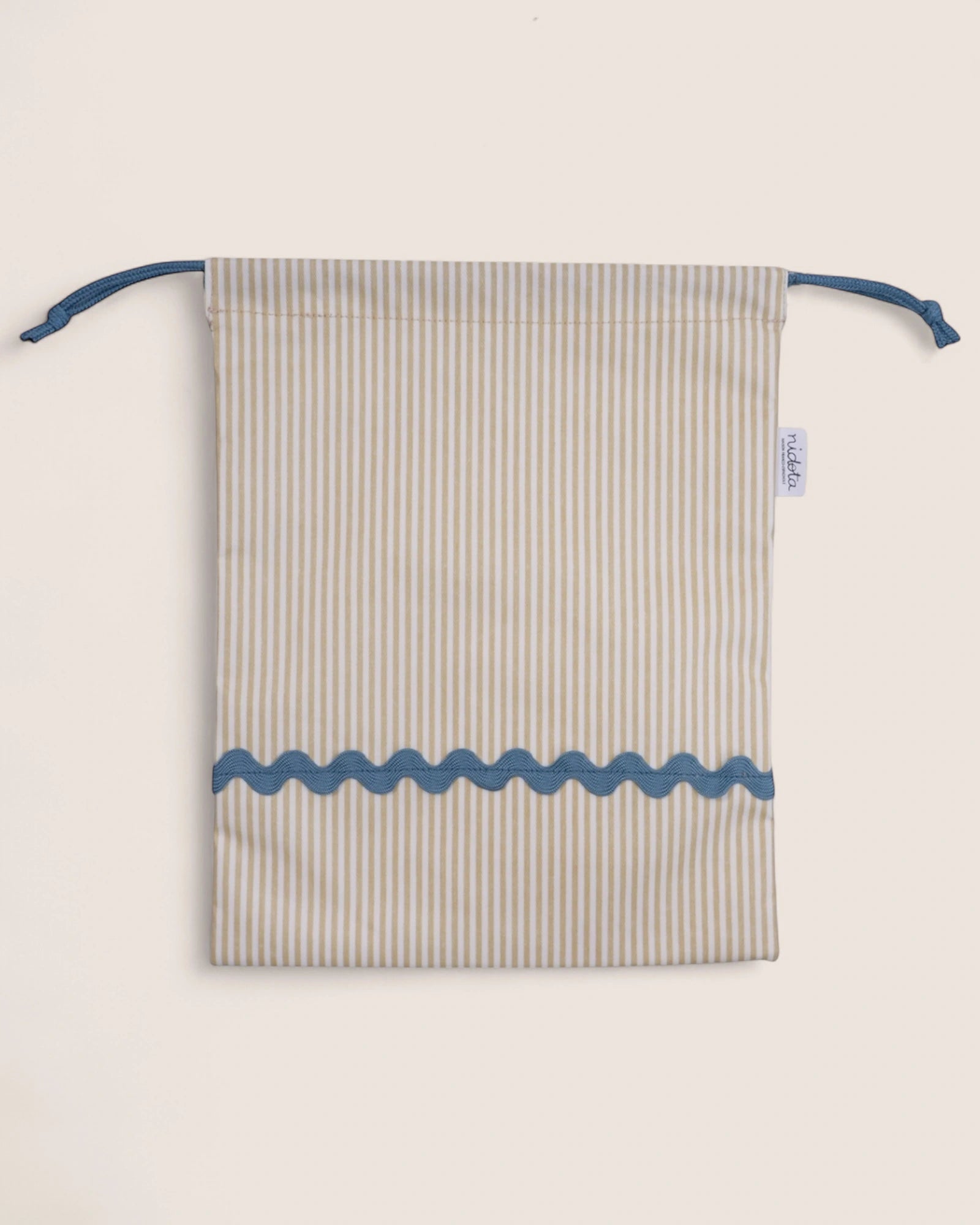 Striped pouch with blue accents on a light beige background