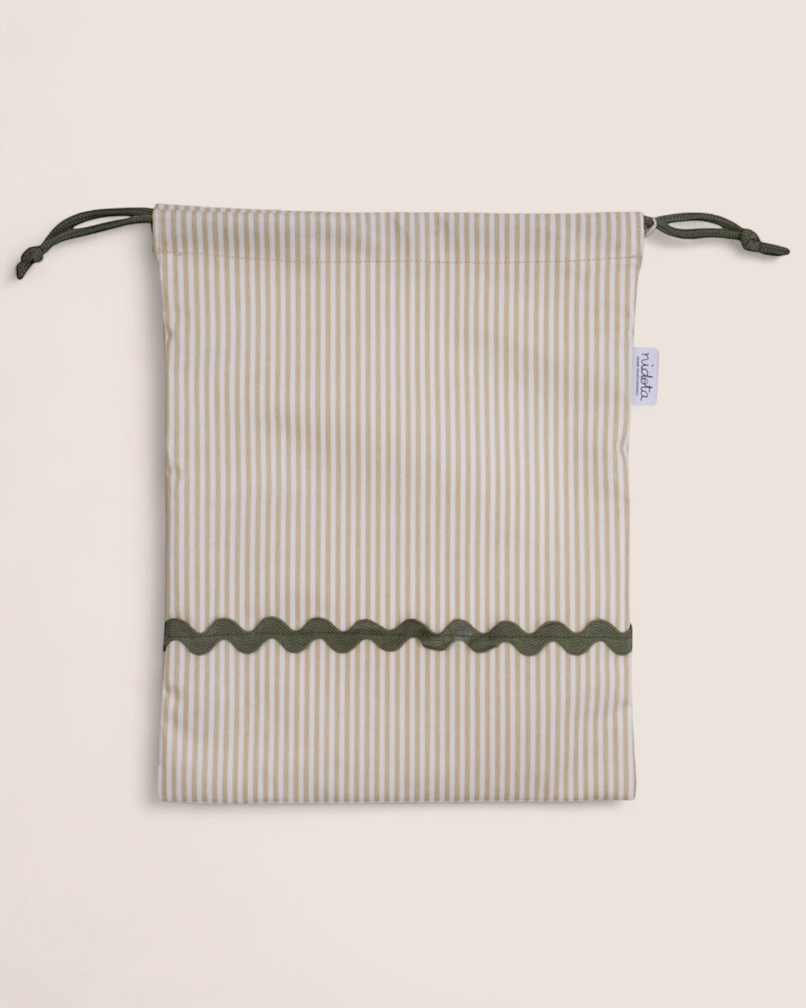 pouch bag with striped pattern and green details on a beige background