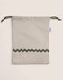 pouch bag with striped pattern and green details on a beige background