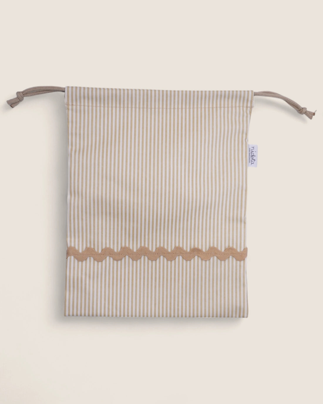 Striped pouch bag with wavy bottom edge on a light beige background