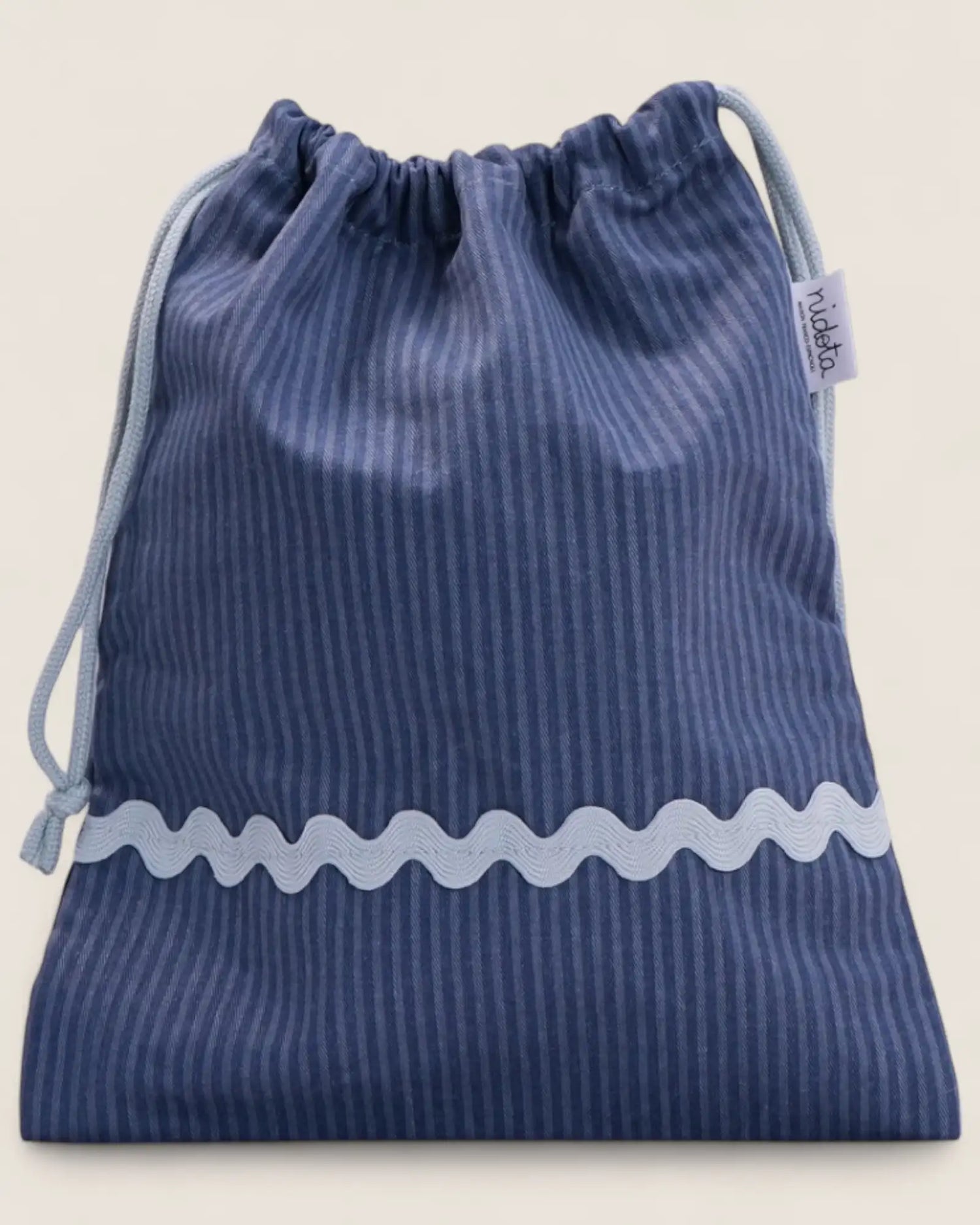 closed Blue striped pouch bag with light blue wavy line on a beige background
