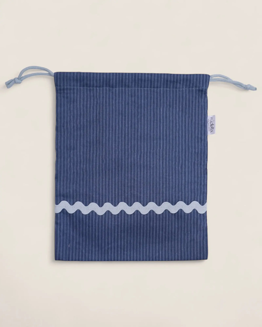 Blue striped pouch bag with light blue wavy line on a beige background