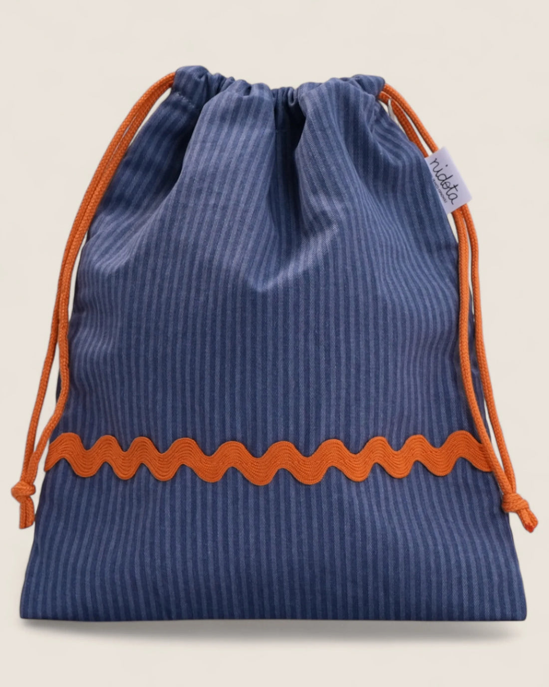 closed striped blue pouch bag with orange waved design on a beige background