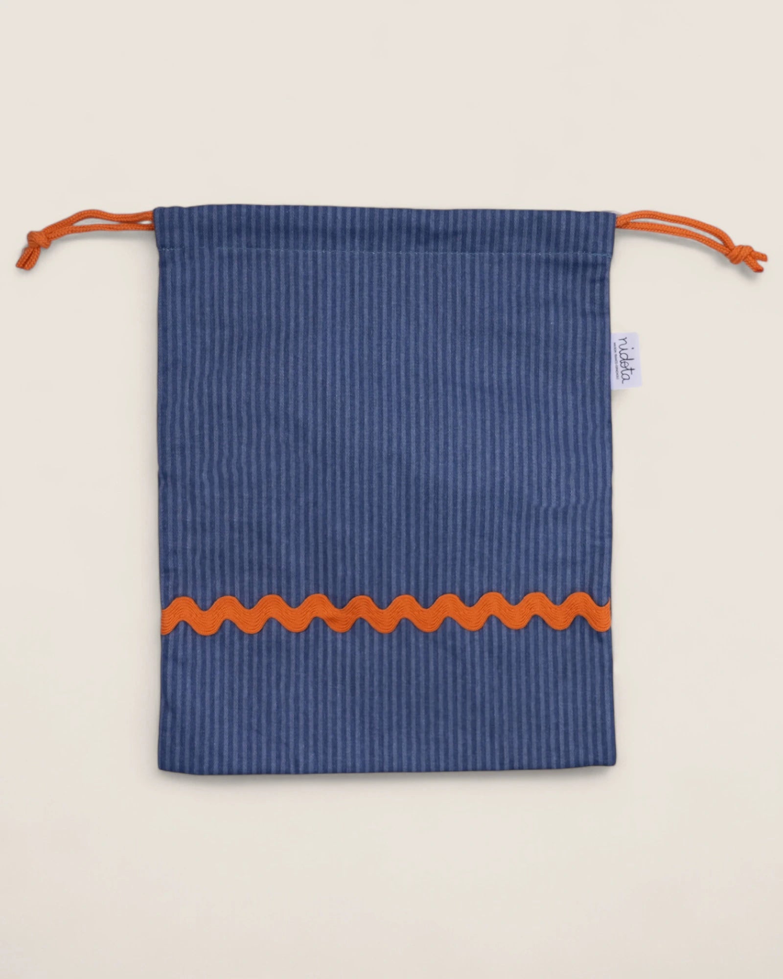 striped Blue pouch bag with orange waved design on a beige background