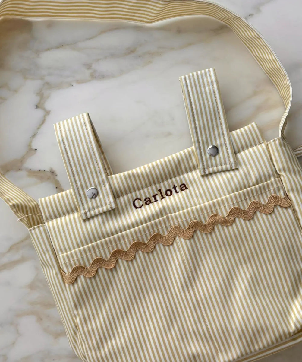 Striped bag with 'Carlota' personalized on a marble surface